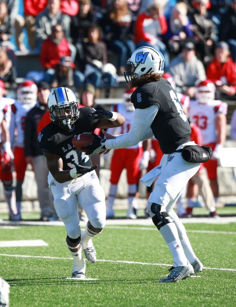 GVL / Kevin Sielaff - Bart Williams (6) hands the ball off to Kirk Spencer (27).  Grand Valley squares off against SVSU Nov. 14 in Allendale. The Lakers hold on and win with a final score of 24-17.