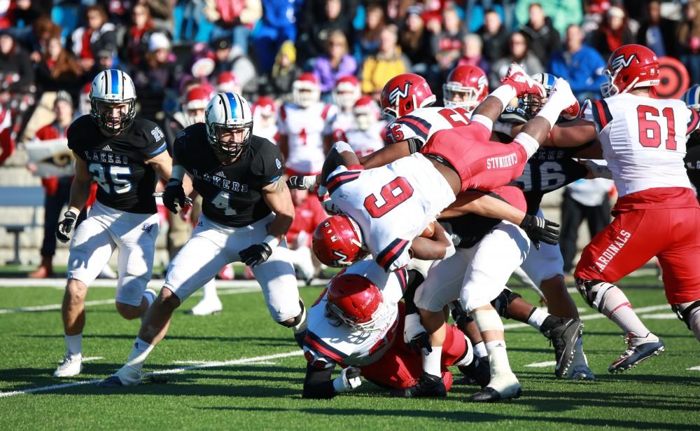 GVL / Kevin Sielaff - Alton Voss (4) looks at the massive tackle happening in front of him.  Grand Valley squares off against SVSU Nov. 14 in Allendale. The Lakers hold on and win with a final score of 24-17.