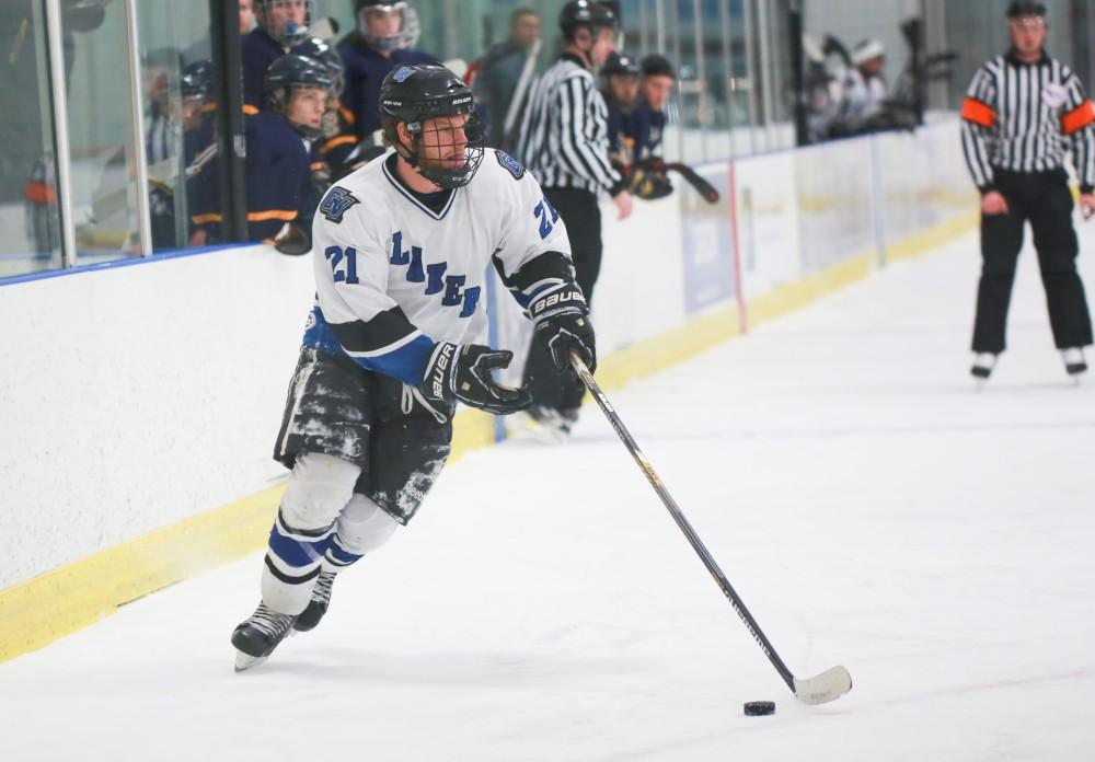 GVL / Kevin Sielaff - Ian Hamilton (21) looks to pass the puck.  The Lakers square off against the Rockets from the University of Toledo Nov. 6 in Allendale.