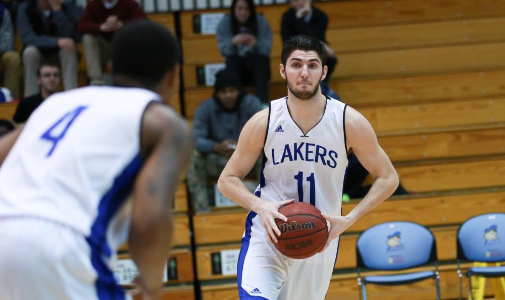 GVL / Kevin Sielaff - Zach West (11) shoots the ball over the Sam McClendon (4) at the top of the arch.  The Laker basketball squad defeats Grace Bible College with a final score of 83-57 Nov. 23 in the fieldhouse arena.