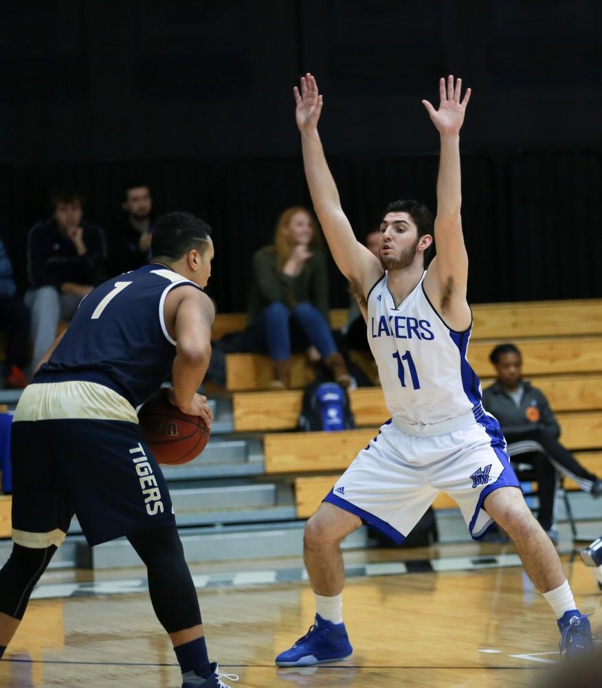 GVL / Kevin Sielaff - Zach West (11) defends a Grace Bible point guard.  The Laker basketball squad defeats Grace Bible College with a final score of 83-57 Nov. 23 in the fieldhouse arena.