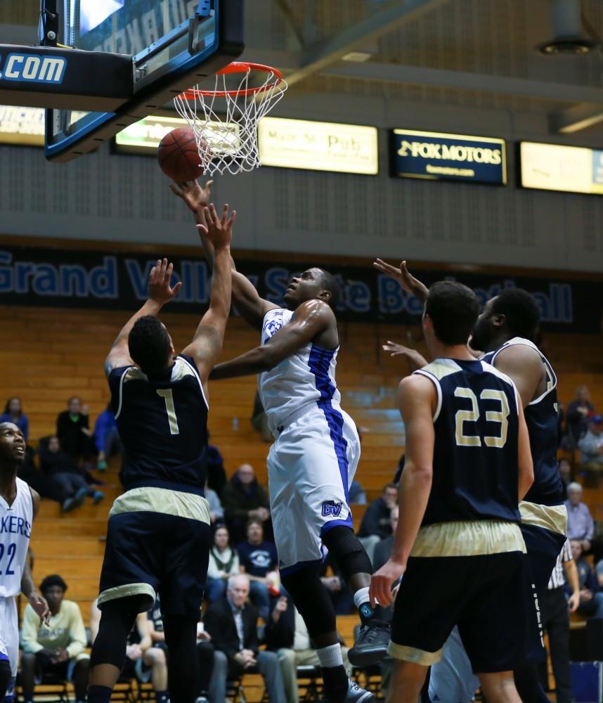 GVL / Kevin Sielaff - Trevin Alexander (5) grabs an offensive rebound and puts the ball back up on net.  The Laker basketball squad defeats Grace Bible College with a final score of 83-57 Nov. 23 in the fieldhouse arena.