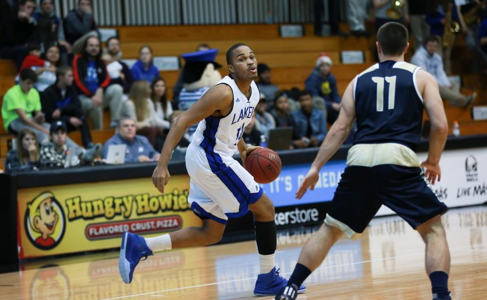 GVL / Kevin Sielaff - Harold Wiggins (14) dribbles the ball around the arch. The Laker basketball squad defeats Grace Bible College with a final score of 83-57 Nov. 23 in the fieldhouse arena.