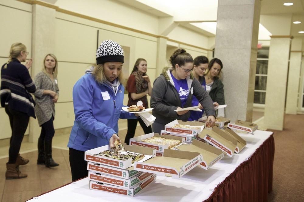 GVL / Sara Carte
Grand Valley students get pizza before the documentary film screening of  “Paper Tigers” in the Cook-DeVos Center for Health Sciences downtown Grand Rapids on Nov. 16.