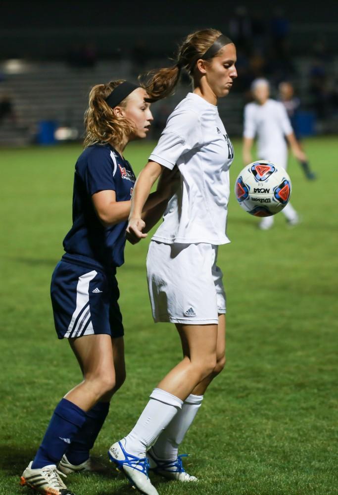 GVL / Kevin Sielaff - Gabriella Mencotti (20) juggles the ball in front of a Malone defender.  Grand Valley defeats Malone in the first round of the GLIAC tournament with a final score of 6-0 Nov. 4 in Allendale.