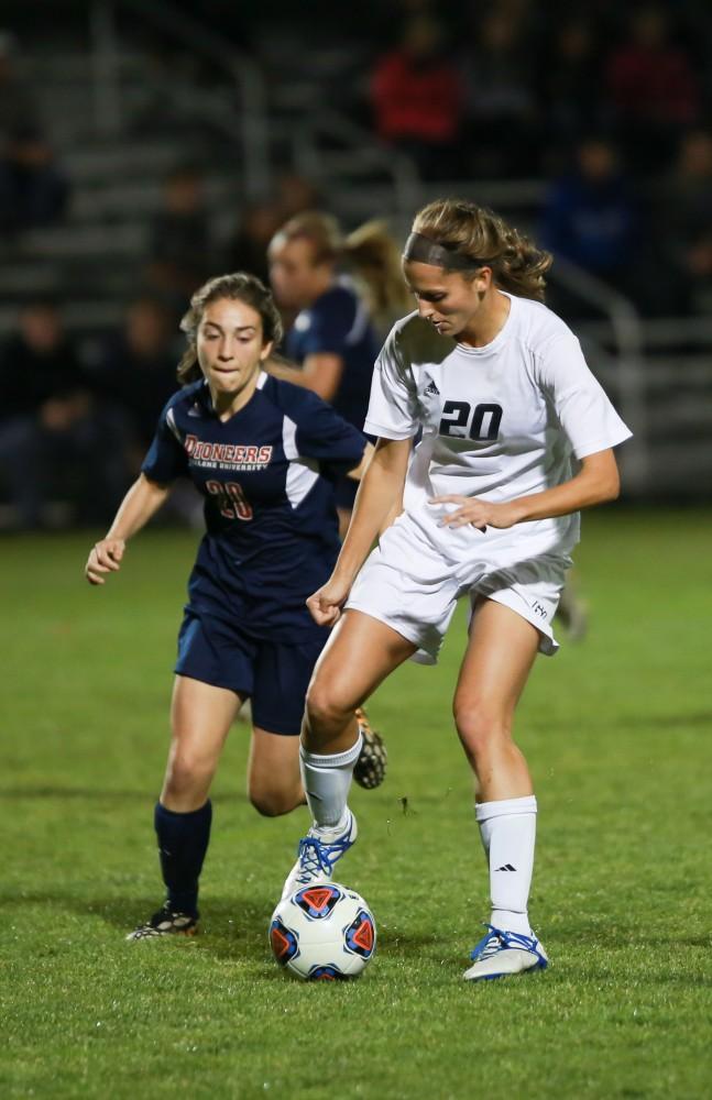 GVL / Kevin Sielaff - Gabriella Mencotti (20) pulls the ball back to evade a Malone midfielder.  Grand Valley defeats Malone in the first round of the GLIAC tournament with a final score of 6-0 Nov. 4 in Allendale.