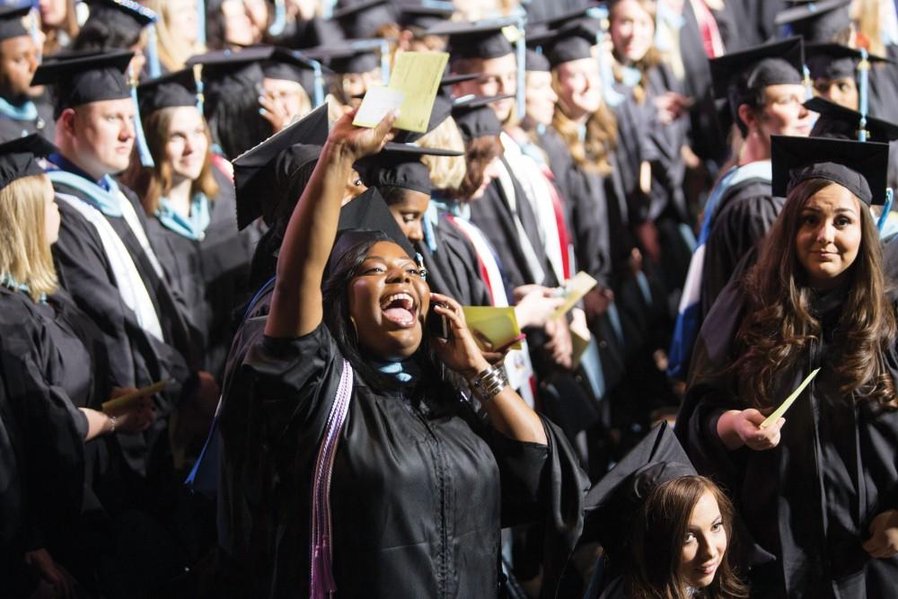GVL/Archive
GVSU graduate waves at her friends and family at the 2015 Commencement April 25.