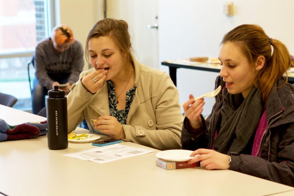 GVL / Sara Carte
Grand Valley students Brice Wingerter (left) and Natalie Pollet (right) eat and celebrate the Dutch holiday, Sinterklaas, in the Kirkhof building on Dec. 4.