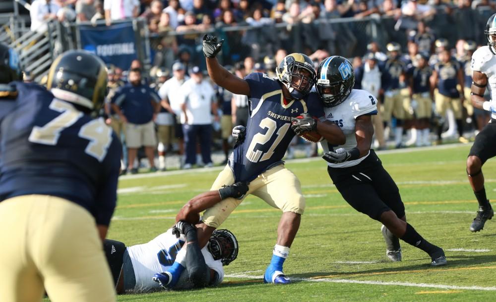 GVL / Kevin Sielaff - Shepard's Jabre Lolley (21) is taken down by Marquez Gollman (2).  The Lakers fall to the Rams of Shepard University with a final score of 34-32 Dec. 12 in Shepardstown, West Virginia.