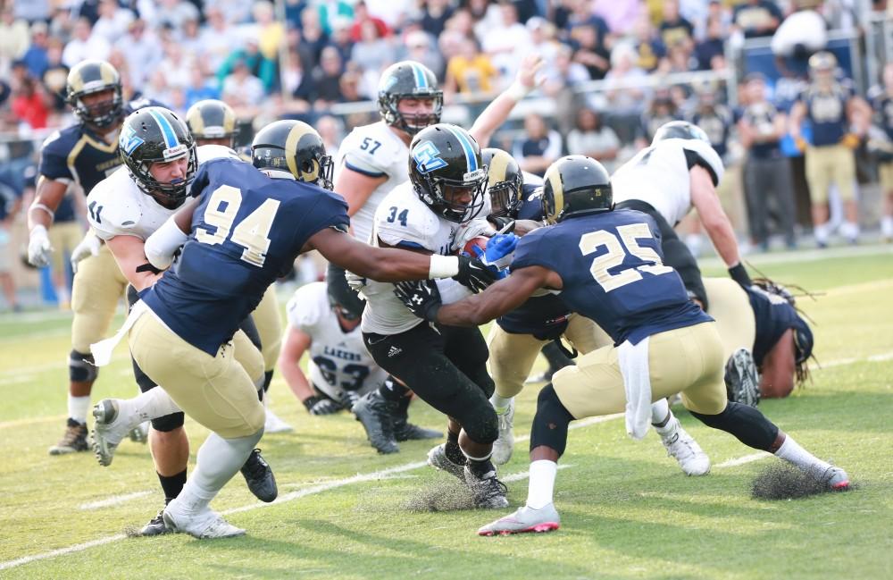 GVL / Kevin Sielaff - Marty Carter (34) is met by Shepard's Keon Robinson (25) and taken down short of the goal line.  The Lakers fall to the Rams of Shepard University with a final score of 34-32 Dec. 12 in Shepardstown, West Virginia.