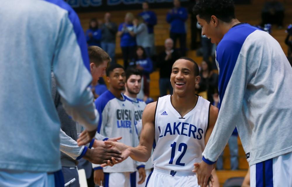 GVL / Kevin Sielaff - Myles Miller (12) is greeted by his teammates before the match.  The Lakers fall to the Eagles of Ashland University in a tough overtime loss Dec. 3 in Allendale. The final score was 76-72.