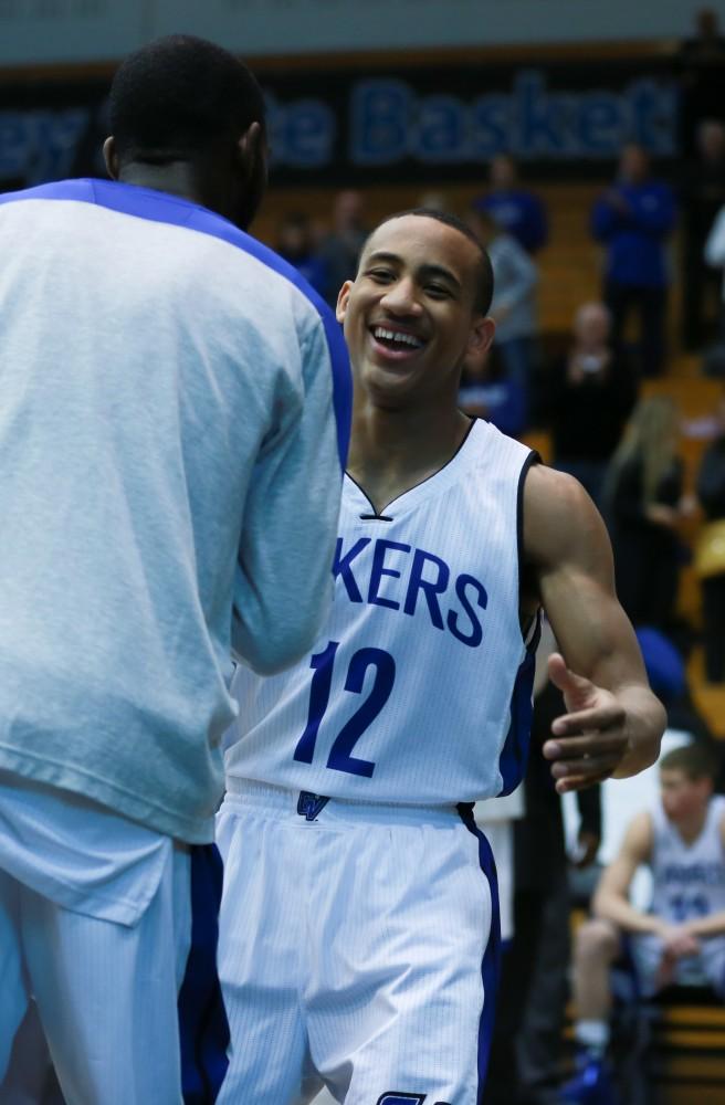 GVL / Kevin Sielaff - Myles Miller (12) is greeted by his teammates before the match.  The Lakers fall to the Eagles of Ashland University in a tough overtime loss Dec. 3 in Allendale. The final score was 76-72.