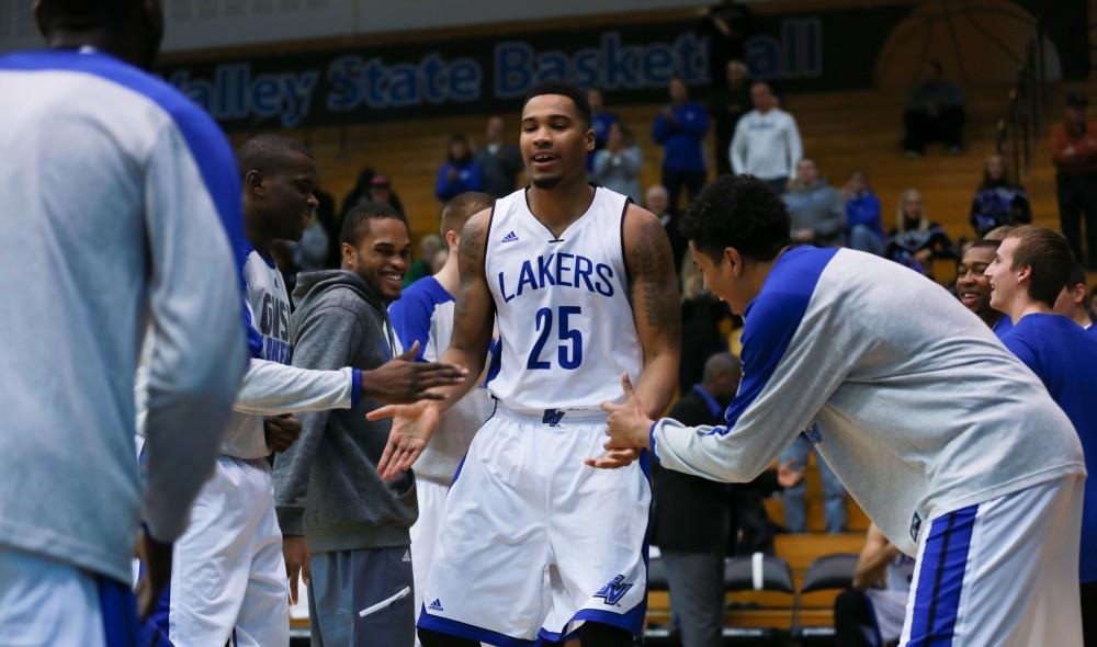 GVL / Kevin Sielaff - Chaz Rollins (25) is greeted by his teammates before the match.  The Lakers fall to the Eagles of Ashland University in a tough overtime loss Dec. 3 in Allendale. The final score was 76-72.