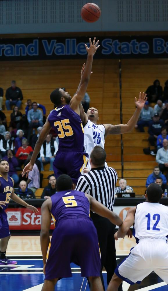 GVL / Kevin Sielaff - Chaz Rollins (25) attemps to win the opening tip.  The Lakers fall to the Eagles of Ashland University in a tough overtime loss Dec. 3 in Allendale. The final score was 76-72.