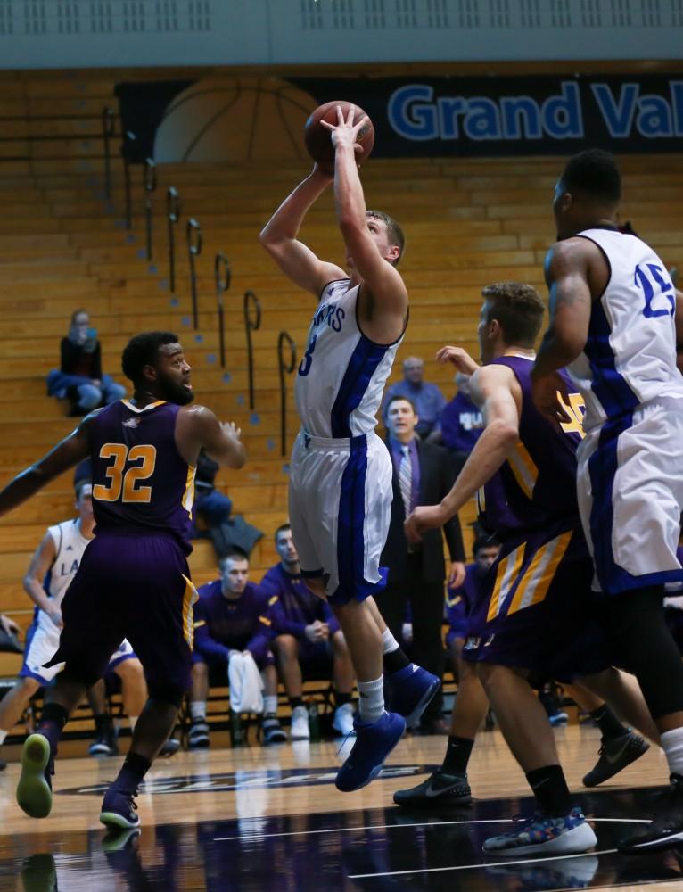 GVL / Kevin Sielaff - Luke Ryskamp (23) drives the ball hard to the net.  The Lakers fall to the Eagles of Ashland University in a tough overtime loss Dec. 3 in Allendale. The final score was 76-72.