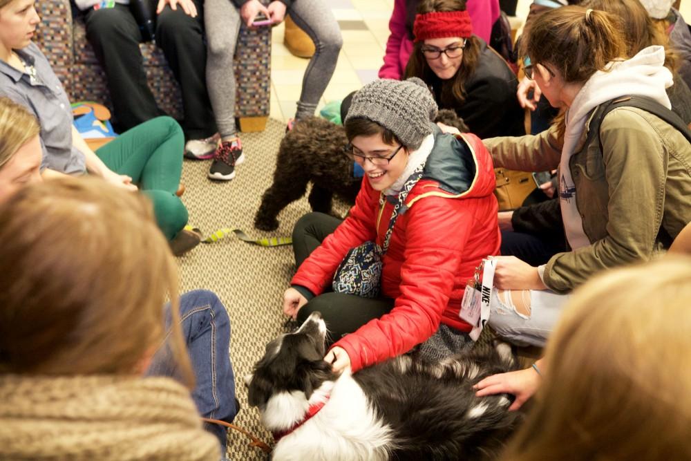 GVL / Sara Carte
Grand Valley students play with therapy puppies to relieve stress from finals week in the Kirkhof building on Dec. 7.