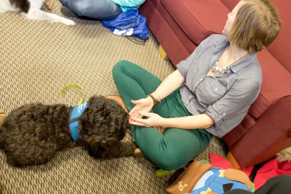 GVL / Sara Carte
Grand Valley students play with therapy puppies to relieve stress from finals week in the Kirkhof building on Dec. 7.