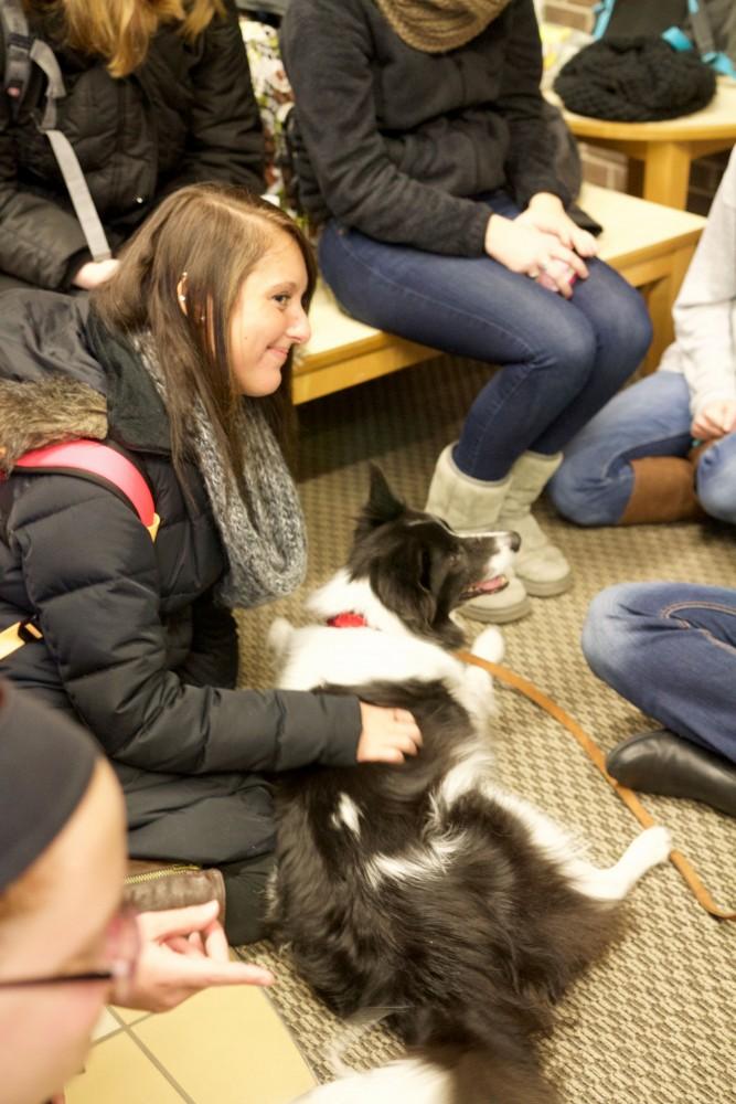 GVL / Sara Carte
Grand Valley students play with therapy puppies to relieve stress from finals week in the Kirkhof building on Dec. 7.