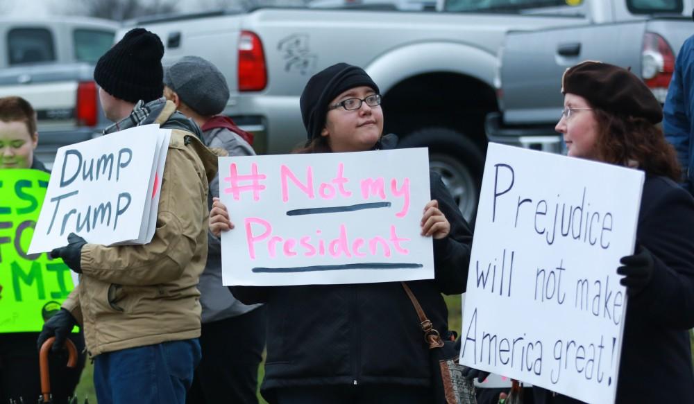 GVL / Kevin Sielaff - Protestors gather near the entrance of the venue to voice their opinions about Donald Trump.  Republican front runner Donald Trump packs the Deltaplex Arena and Conference Center in downtown Grand Rapids Dec. 21 for a presidential rally. The event boasted the largest crowd ever held at the Deltaplex arena.