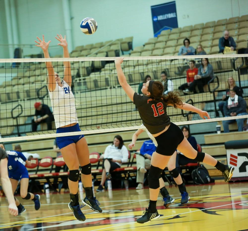 GVL / Kevin Sielaff - Staci Brower (21) leaps up to block a Lewis tip.  The Lakers fall to the Flyers of Lewis University Dec. 3 in Big Rapids, MI in the first round of the NCAA midwest regional tournament by a margin of 3-1.