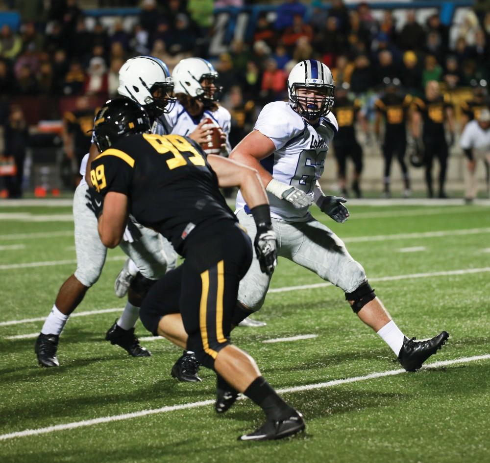 GVL / Kevin Sielaff -  Ben Walling (63) back pedals to block Bart Williams (6).  Grand Valley squares off against Michigan Tech Oct. 17 at Lubbers Stadium in Allendale. The Lakers defeated the Huskies with a score of 38-21.