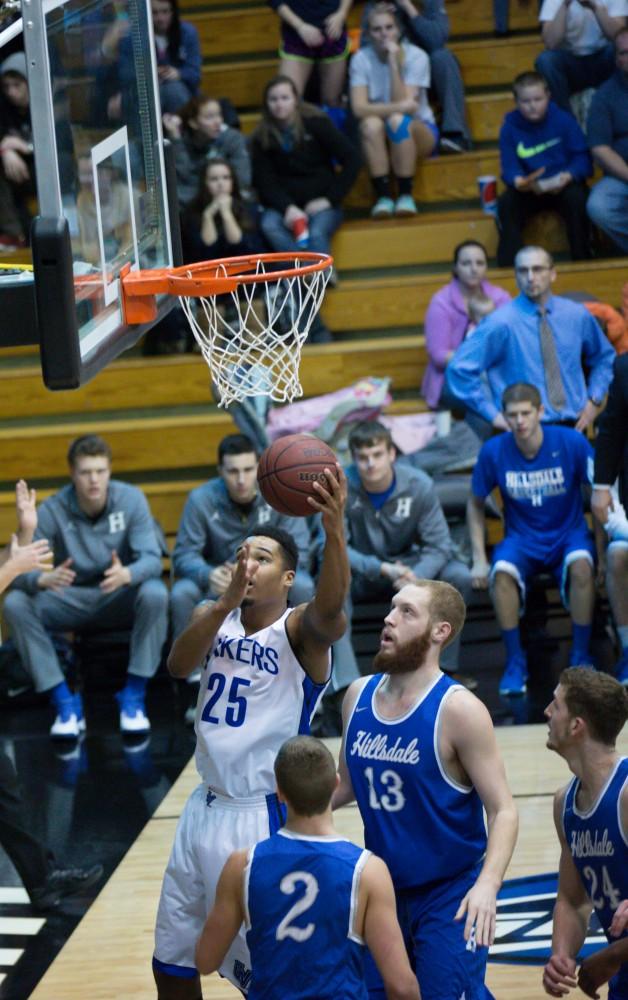 GVL / Kevin Sielaff - Chaz Rollins (25) finds his way under the hoop and tries a layup.  The Lakers defeat the Chargers of Hillsdale College Saturday, Jan. 30, 2016 in Allendale.