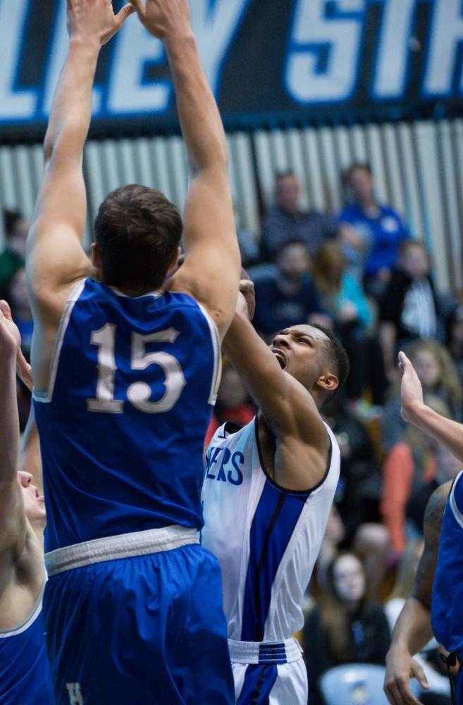 GVL / Kevin Sielaff - Aaron Hayes (1) pulls up for a shot but is contested by Hillsdale's Nick Archer (15).  The Lakers defeat the Chargers of Hillsdale College Saturday, Jan. 30, 2016 in Allendale.