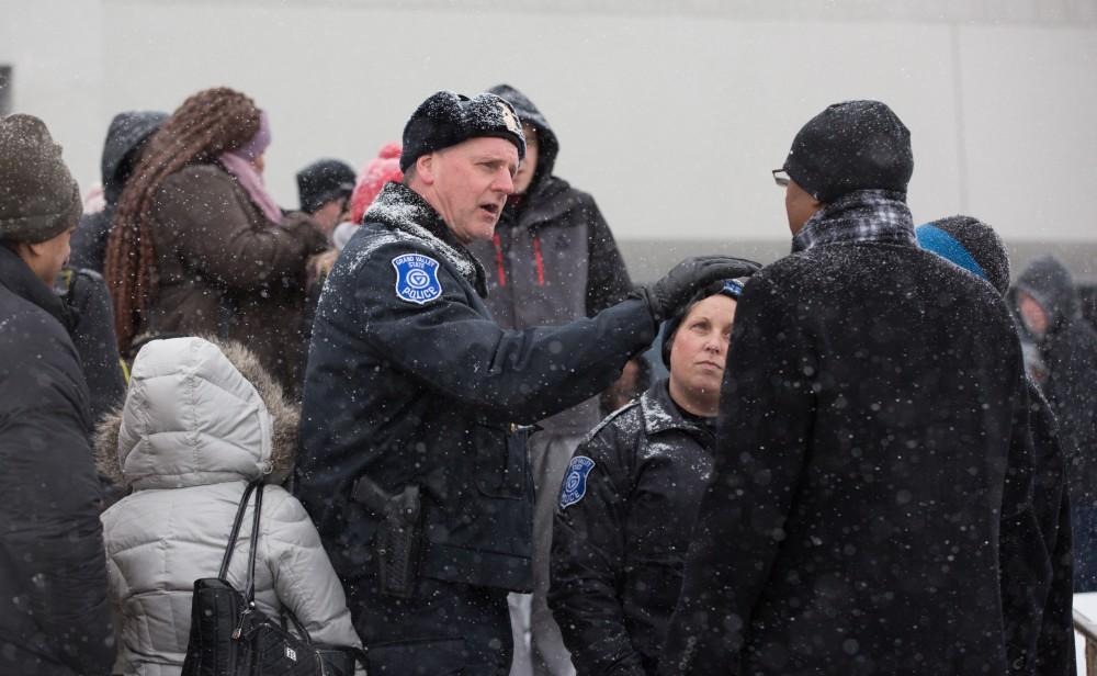 GVL / Kevin Sielaff - GVPD Captain Brandon DeHaan coordinates with those participating in the silent march to ensure a smooth transition into the Fieldhouse Arena.  Touré, Vice columnist and well known author, visits Grand Valley's Allendale campus on a chilly Jan. 18, 2016. Hundreds of students gathered inside the Fieldhouse to listen to Touré's keynote speech; the students also participated in a silent march before the event.