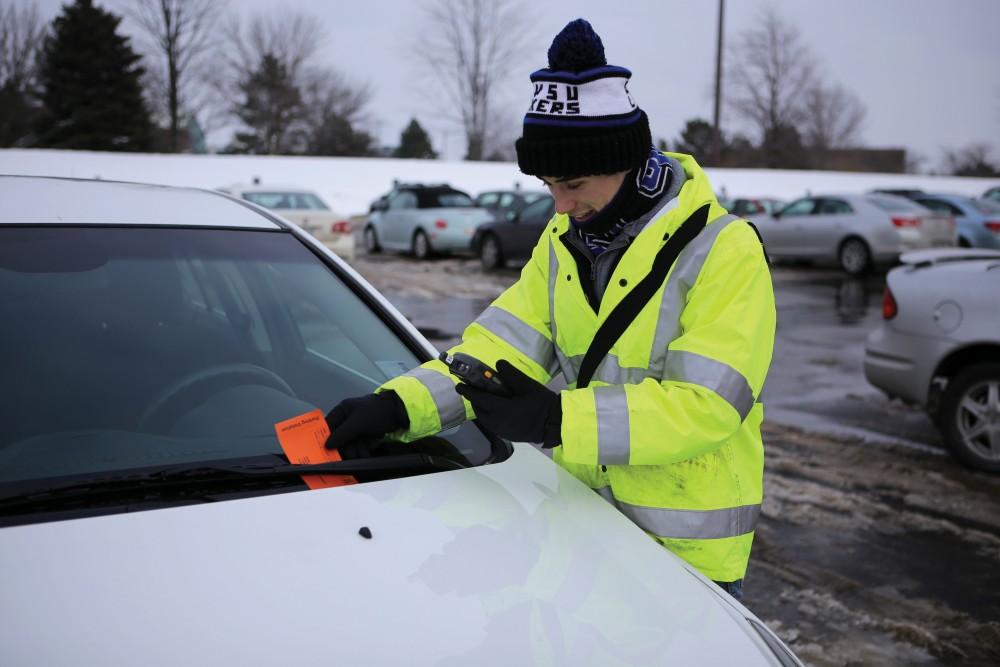GVL / Emily Frye Junior Chad Jackson gives out a parking citation to one unlucky student in Lot H on Jan. 23rd.