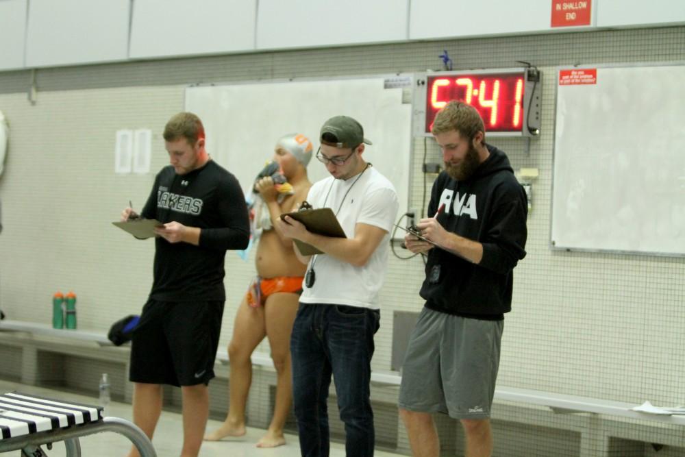 Volunteers keep record of times during the swimmeat against Findlay on Jan 23 in Allendale, MI. 