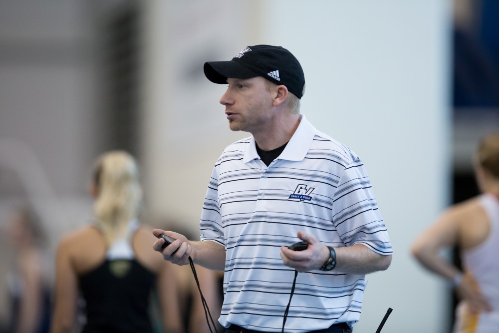 GVL / Kevin Sielaff - Head coach Jerry Baltes times the women's mile run.  The Kelly Family Sports Center hosts the Bob Eubanks Open Jan. 15, 2016.