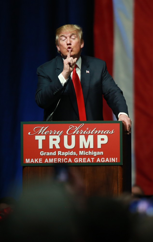 GVL / Kevin Sielaff - Donald Trump hushes a protester in the front row. Republican front runner Donald Trump packs the Deltaplex Arena and Conference Center in downtown Grand Rapids Dec. 21 for a presidential rally. The event boasted the largest crowd ever held at the Deltaplex arena.