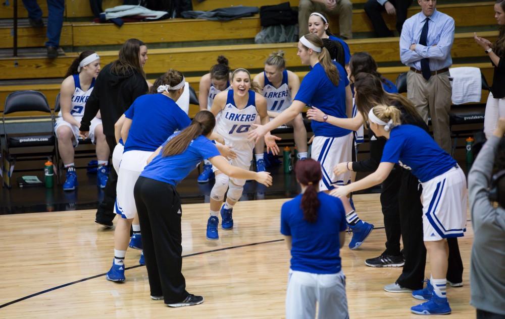 GVL / Kevin Sielaff - Taylor Lutz (10) runs onto the court before the match and is greeted by her teammates.  The Lakers defeat the Chargers of Hillsdale College Saturday, Jan. 30, 2016 in Allendale.