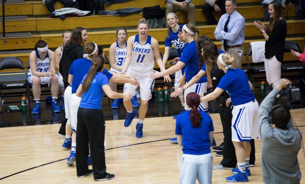 GVL / Kevin Sielaff - Piper Tucker (11) runs onto the court and is greeted by her teammates before the match.  The Lakers defeat the Chargers of Hillsdale College Saturday, Jan. 30, 2016 in Allendale.