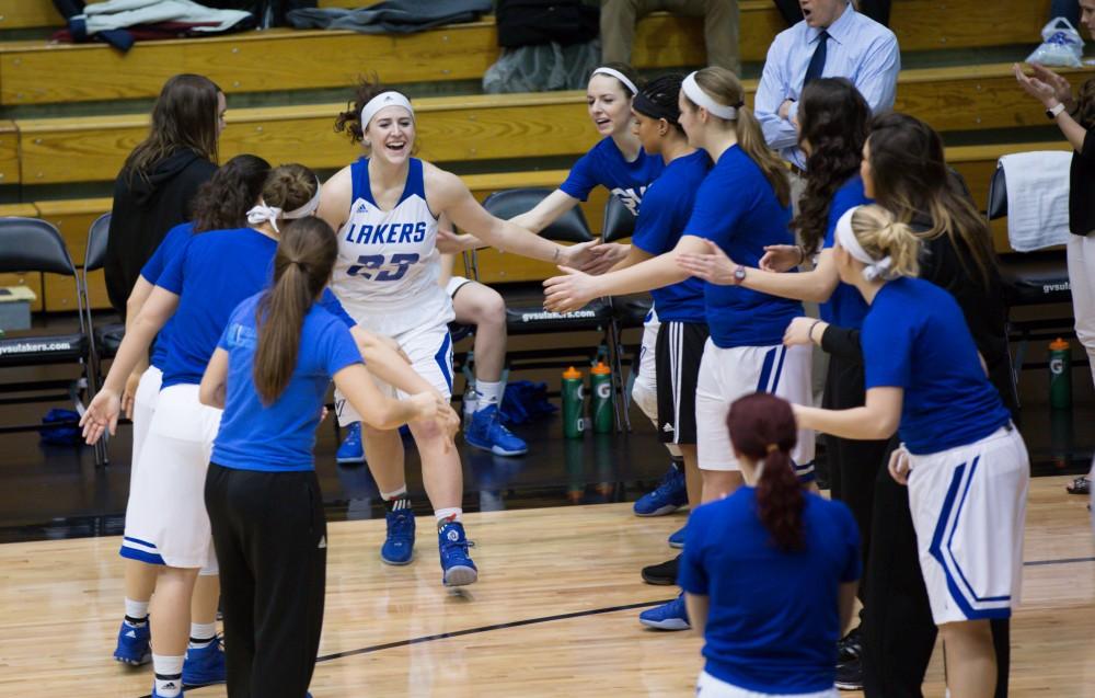 GVL / Kevin Sielaff - Kayla Dawson (23) runs onto the court before the match.  The Lakers defeat the Chargers of Hillsdale College Saturday, Jan. 30, 2016 in Allendale.