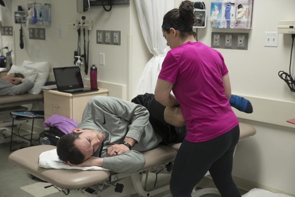 GVL / Luke HolmesMelissa Perla helps strectch out Grant Fall in the Physical Therapy room in the Center for Health Sciences Wednesday, Feb. 10, 2016.