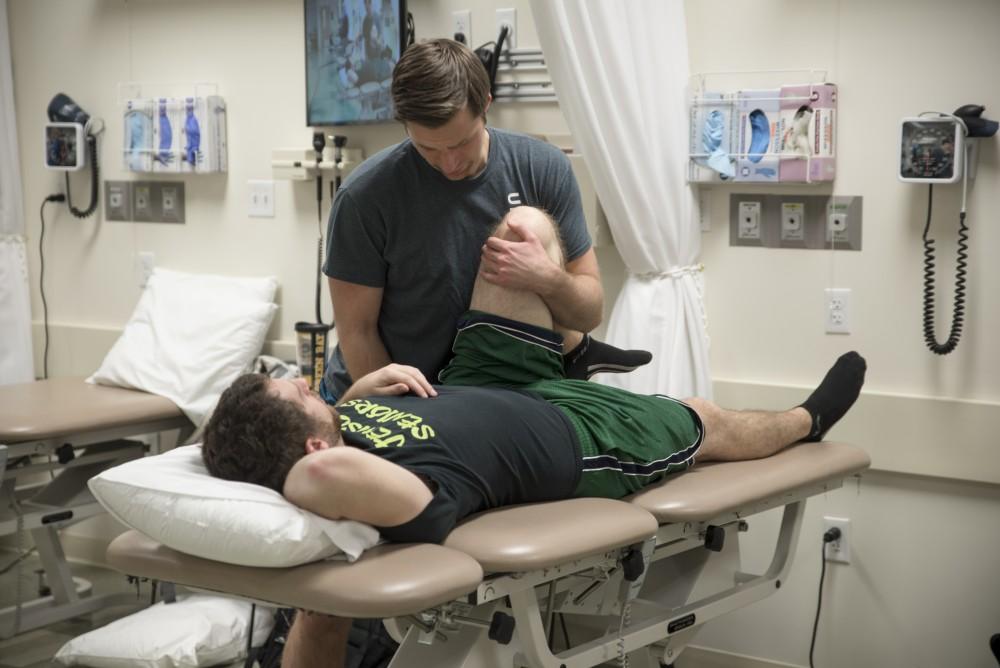 GVL / Luke Holmes
Mike Phillips helps his fellow classmate with some stretching exercises in the physical therapy room in the Center for Health Sciences Wednesday, Feb. 10, 2016.