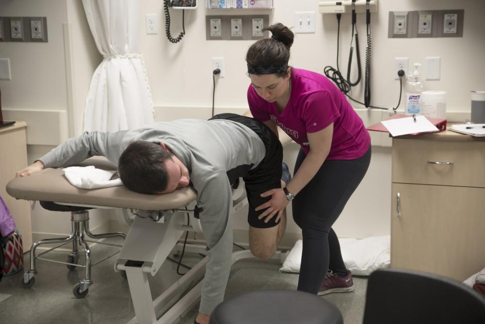 GVL / Luke Holmes
Melissa Perla helps strectch out Grant Fall in the Physical Therapy room in the Center for Health Sciences Wednesday, Feb. 10, 2016.