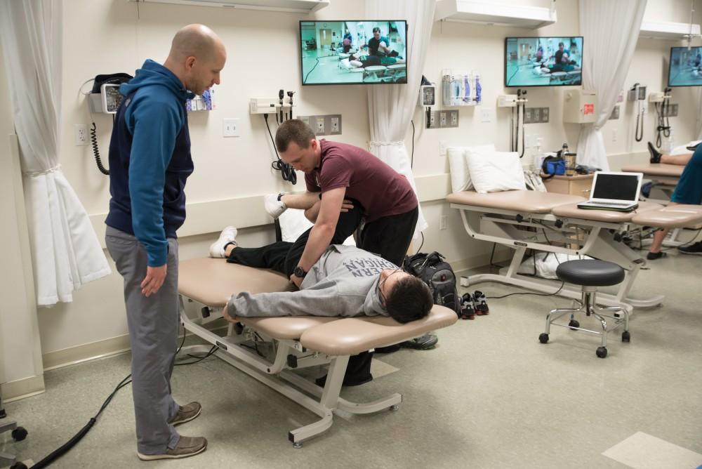 GVL / Luke Holmes
Two Grand Valley Students help each other practice physical therapy as the professor observes in the Center for Health Sciences Wednesday, Feb. 10, 2016.