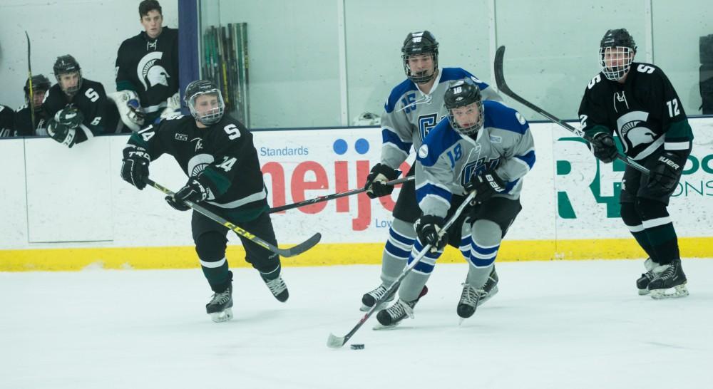 GVL / Kevin Sielaff - Eric White (18) skates the puck in on MSU's net.  The Lakers’ D3 men’s hockey team blows out Michigan State at Eagle Ice Center in Grand Rapids on Friday, February 12, 2016.