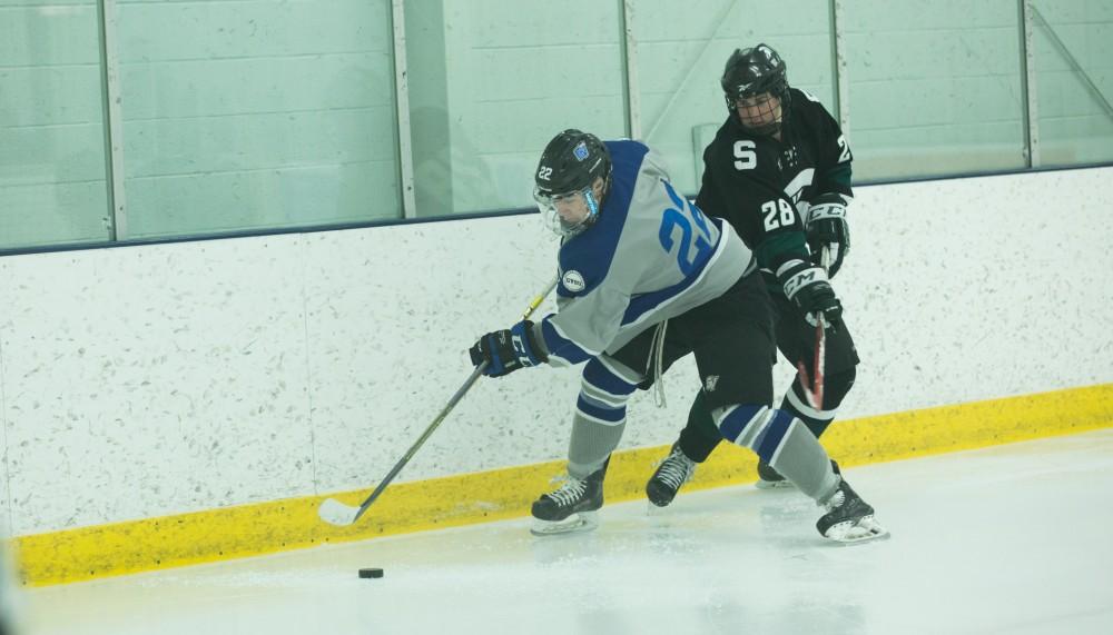 GVL / Kevin Sielaff - Alex Bjork (22) fights to maintain posession of the puck along the boards.  The Lakers’ D3 men’s hockey team blows out Michigan State at Eagle Ice Center in Grand Rapids on Friday, February 12, 2016.