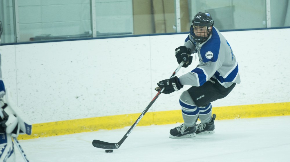 GVL / Kevin Sielaff - Derek Simon (12) skates the puck out of Grand Valley's zone. The Lakers’ D3 men’s hockey team blows out Michigan State at Eagle Ice Center in Grand Rapids on Friday, February 12, 2016.