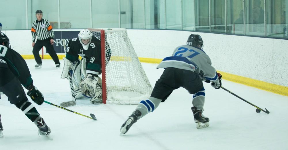 GVL / Kevin Sielaff - Corey Smith (27) skates behind MSU's net to retrieve the puck.  The Lakers’ D3 men’s hockey team blows out Michigan State at Eagle Ice Center in Grand Rapids on Friday, February 12, 2016.