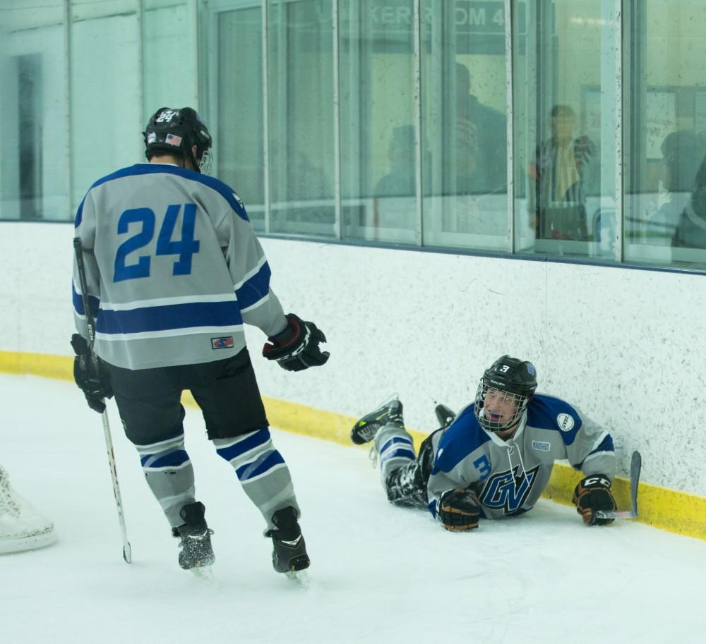 GVL / Kevin Sielaff - Danny Smith (3) flies into the boards after scoring a goal and is helped up by Mitch Kahl (24). The Lakers’ D3 men’s hockey team blows out Michigan State at Eagle Ice Center in Grand Rapids on Friday, February 12, 2016.