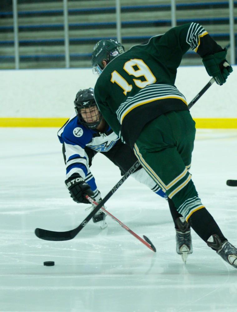 GVL / Kevin Sielaff - Collin Finkhouse (19) reaches in for a poke check against an EMU offenseman.  The Lakers defeat the Eagles of Eatern Michigan University Friday, Feb. 5, 2016 at Georgetown Ice Center.