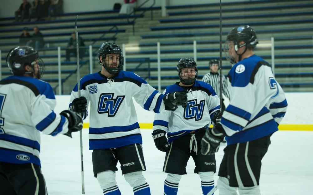 GVL / Kevin Sielaff - Troy Marrett (2) puts in a goal and celebrates with his teammates.  The Lakers defeat the Eagles of Eatern Michigan University Friday, Feb. 5, 2016 at Georgetown Ice Center.