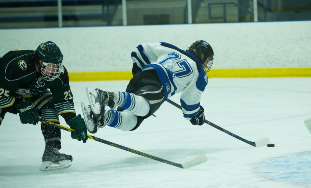 GVL / Kevin Sielaff - Tripped up in the crease, Corbin Rainey (27) tries a shot in mid-air.  The Lakers defeat the Eagles of Eatern Michigan University Friday, Feb. 5, 2016 at Georgetown Ice Center.