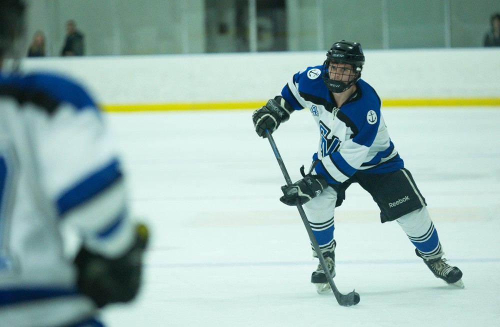 GVL / Kevin Sielaff - Tom Lusynski (4) passes the puck off to a teammate.  The Lakers defeat the Eagles of Eatern Michigan University Friday, Feb. 5, 2016 at Georgetown Ice Center.