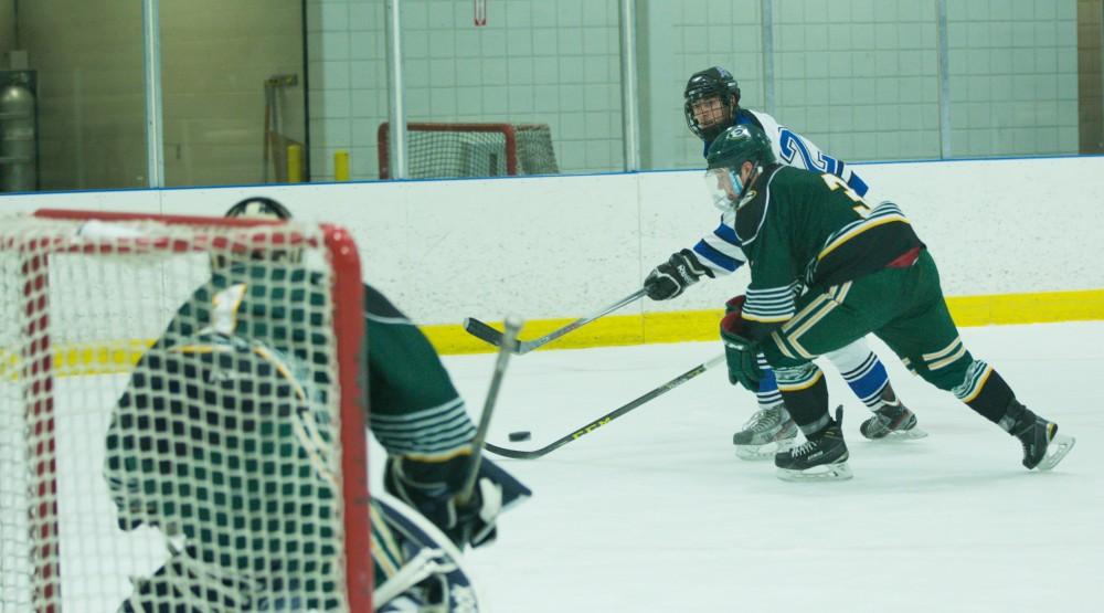 GVL / Kevin Sielaff - Zac Strain (22) tries a back handed shot on net and scores.  The Lakers defeat the Eagles of Eatern Michigan University Friday, Feb. 5, 2016 at Georgetown Ice Center.