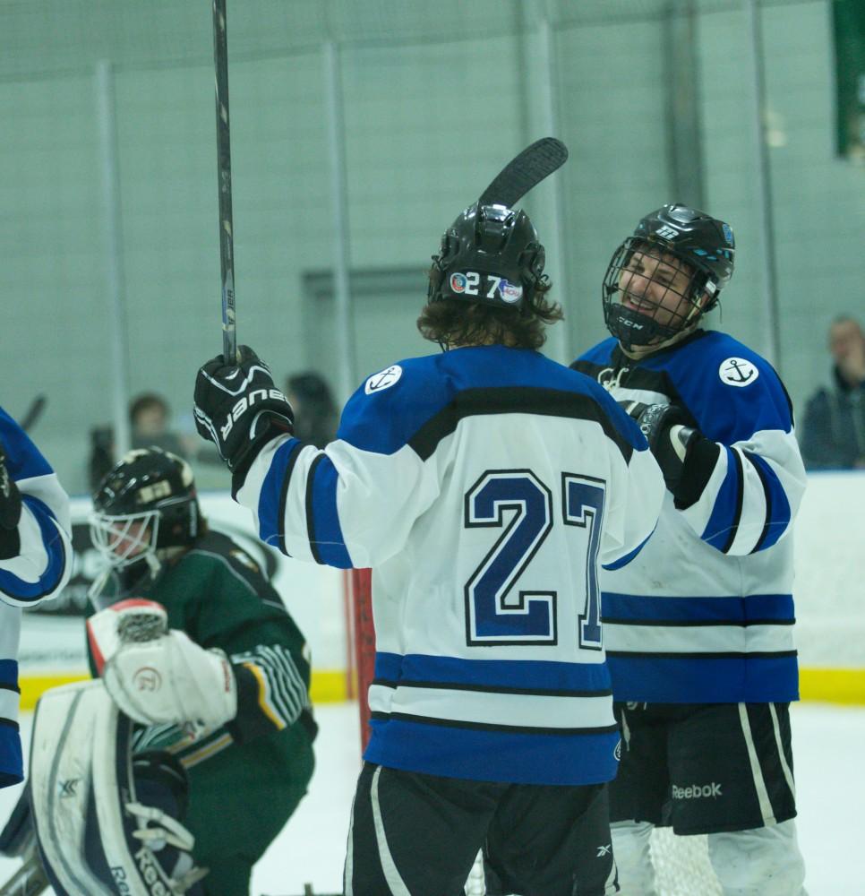 GVL / Kevin Sielaff - Corbin Rainey (27) and Nick Schultz (25) celebrate a goal. The Lakers defeat the Eagles of Eatern Michigan University Friday, Feb. 5, 2016 at Georgetown Ice Center.